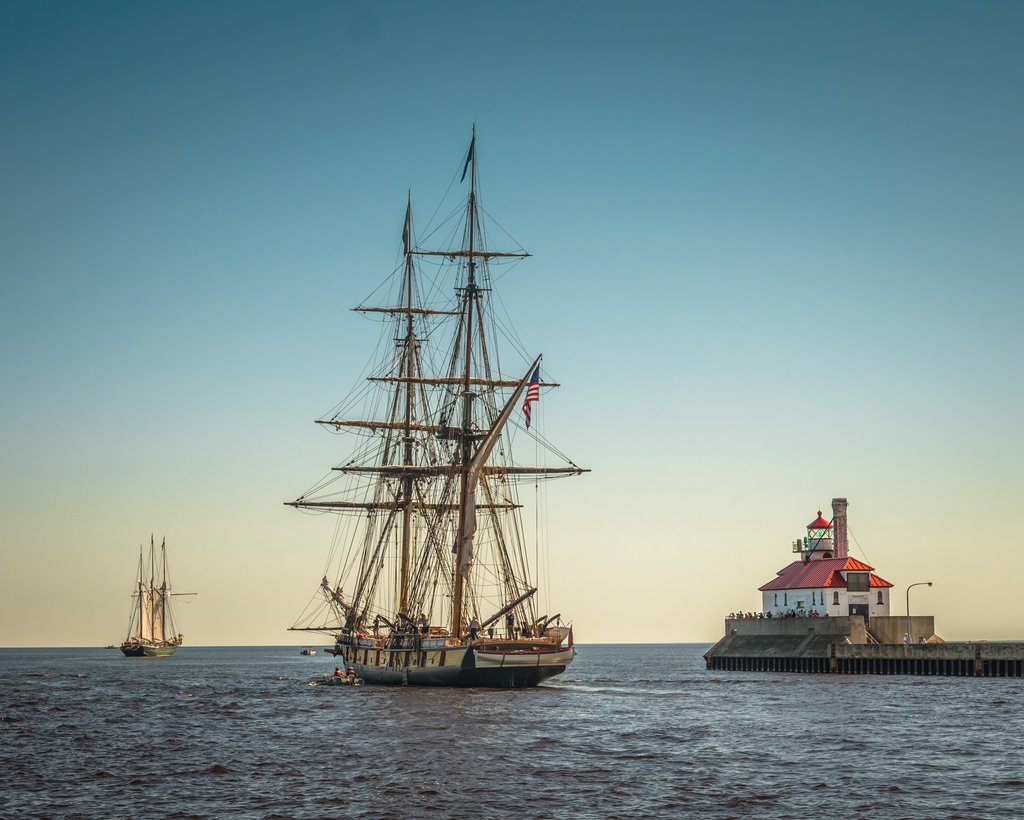 two tall ships and harbor light
